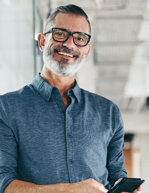 Directeur financier souriant, téléphone en main
