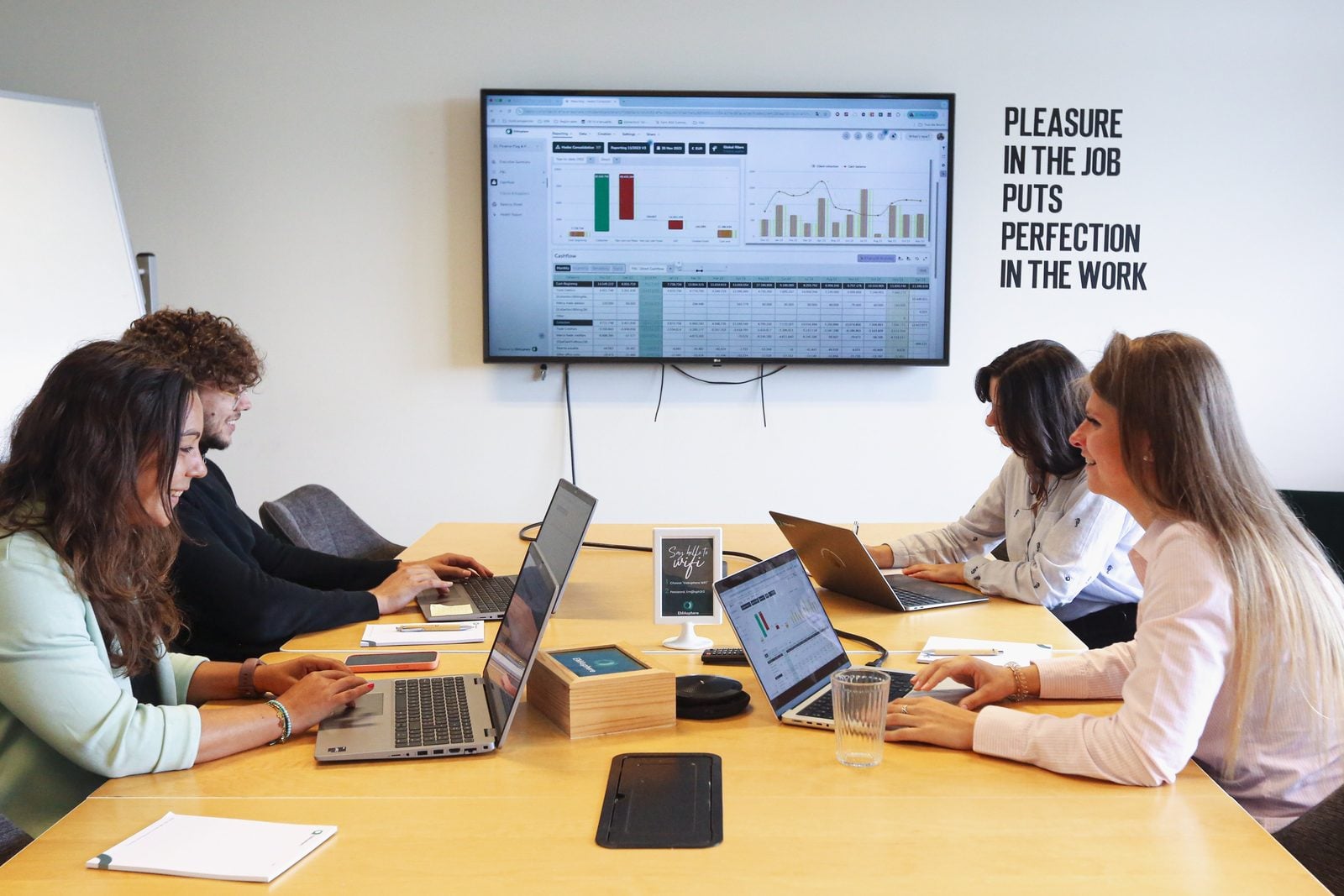 Quatre membres de l'équipe EMASPHERE en réunion, un tableau de bord EMASPHERE à l'écran